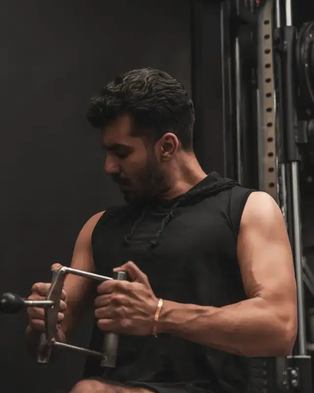 A man training on a cable machine in a gym